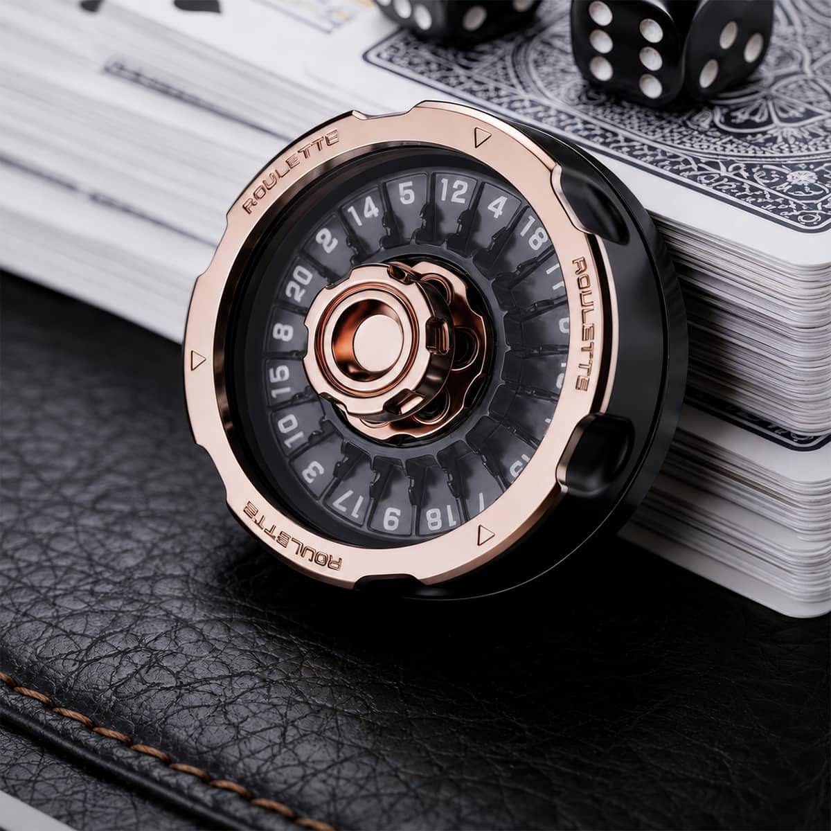 Rose gold and black metal D20 decision spinner beside playing cards and black dice.