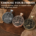 Silver, copper and antique bronze pocket press dice displayed on a leather tabletop.