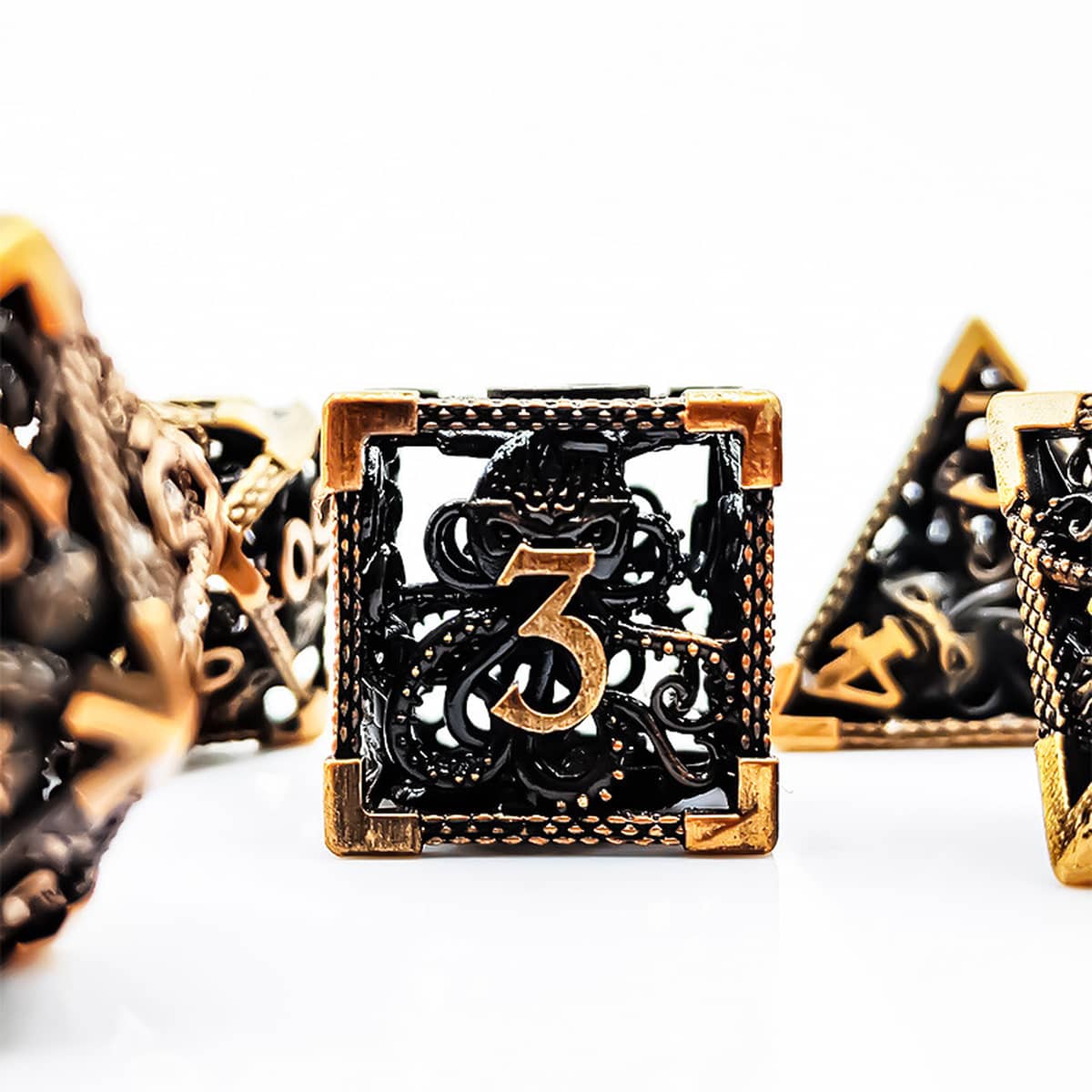 Close-up of an antique gold hollow metal D6 with sculpted tentacle openwork.