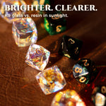 Rainbow-reflective K9 glass dice and dark resin dice shown in sunlight.