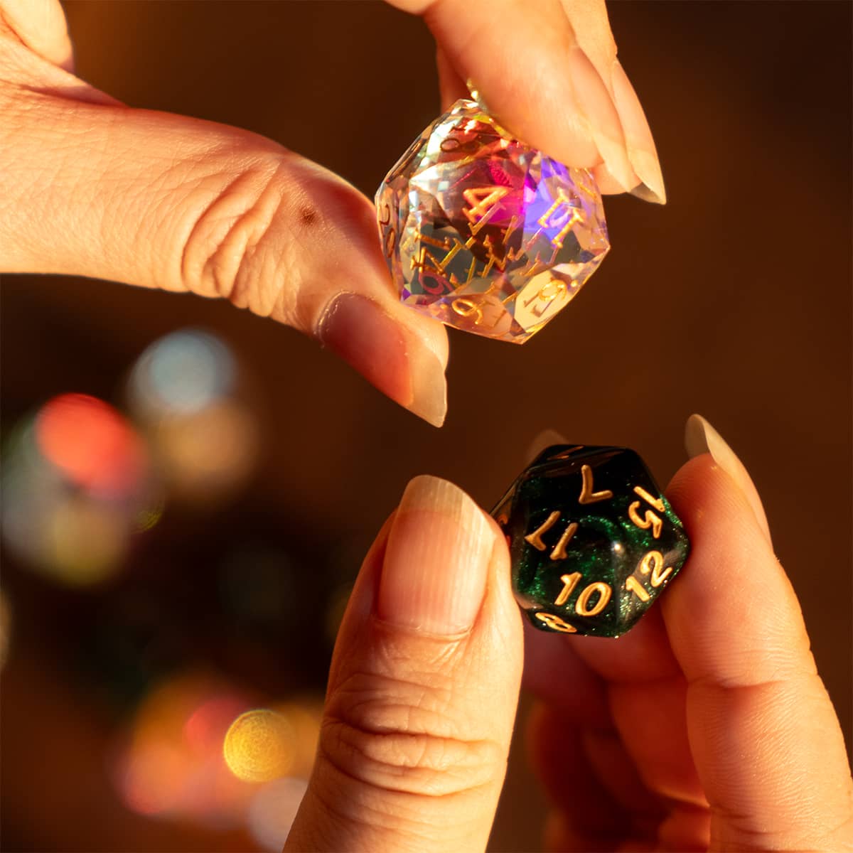 Hands comparing a clear rainbow-reflective glass D20 with a dark green resin D20.